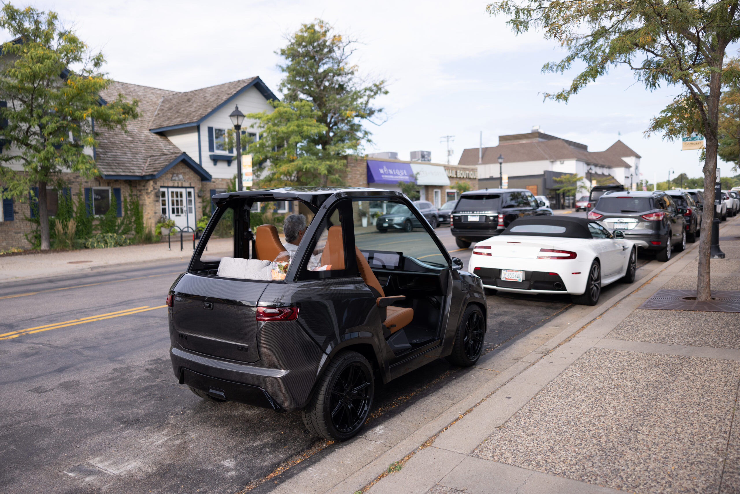 Man sitting in a ULV 322 in gray parked at the curb waiting with flowers in the back of the vehicle