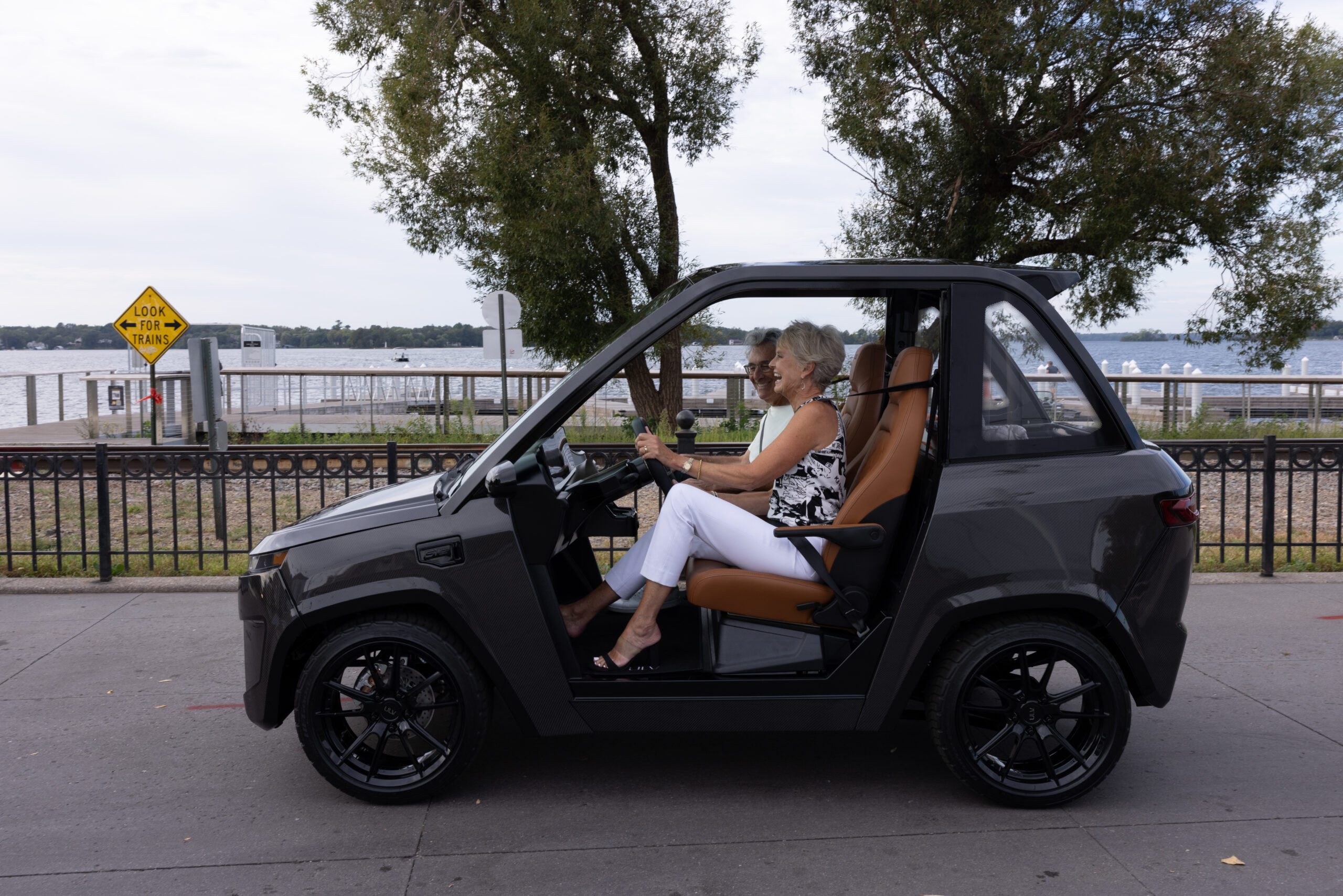 A couple drives a ULV 322 in gray past a lake