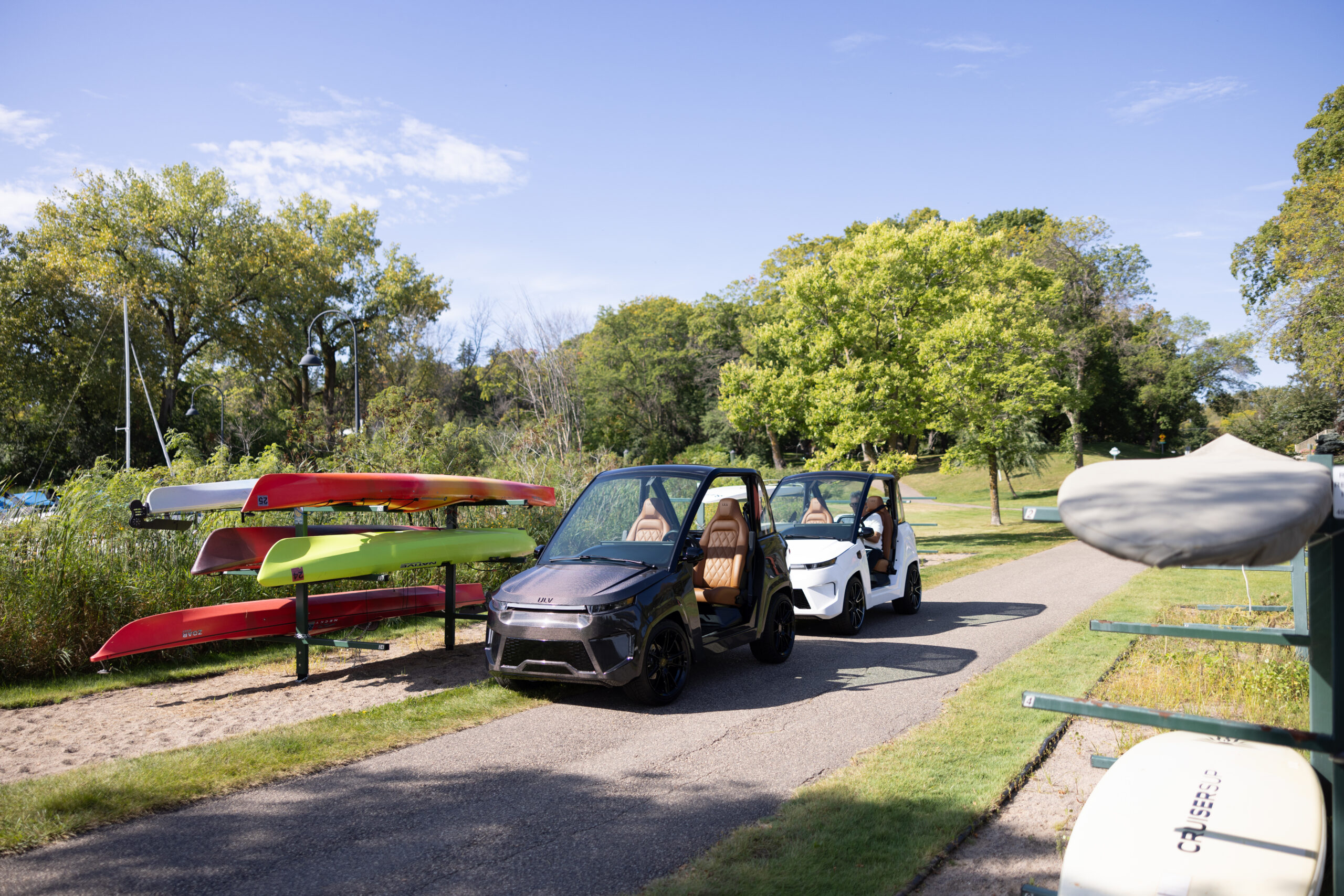 ULV 322 carbon in black and a 322 in white parked on a path near water sports equipment