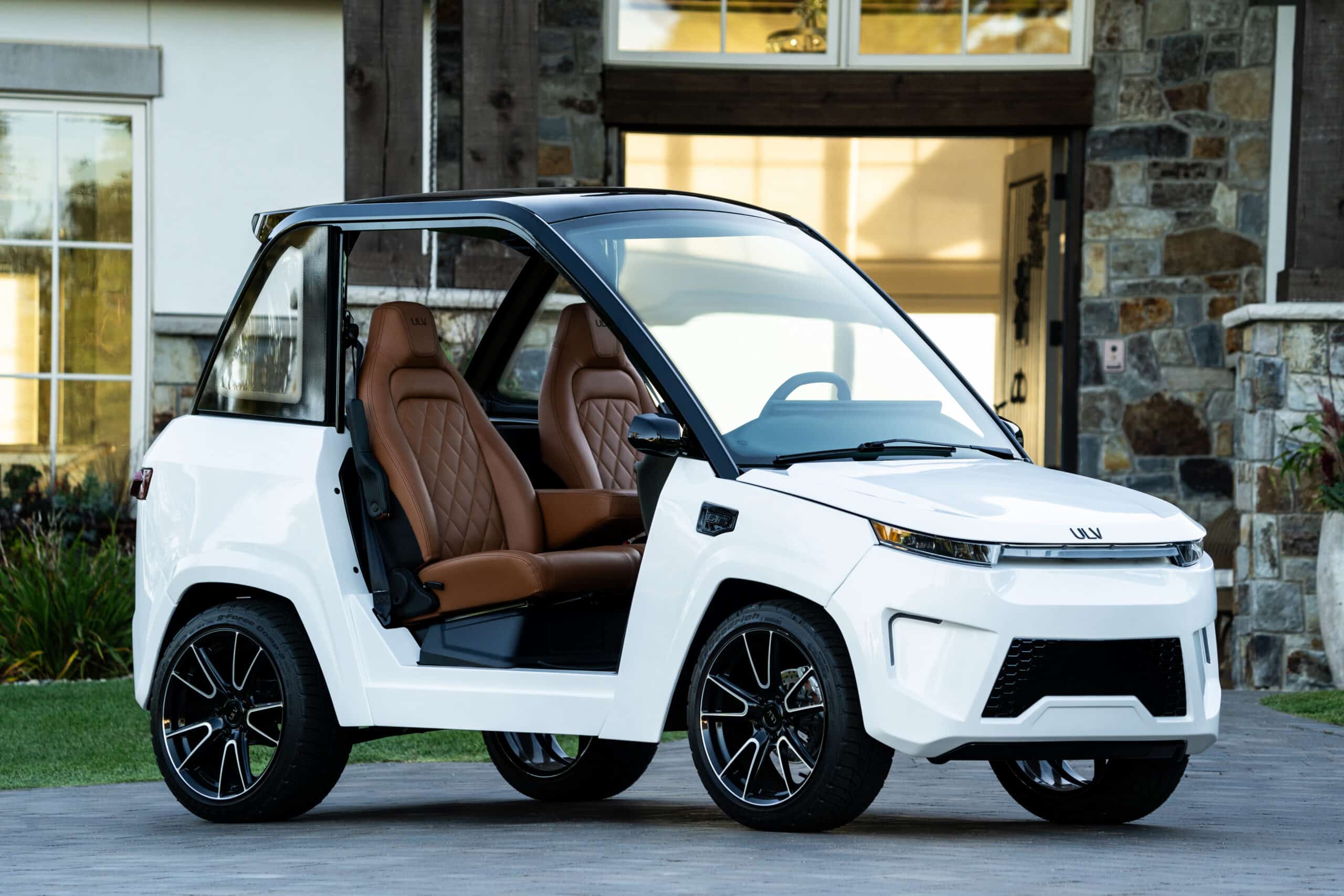 ULV 322 in white parked in front of a large lakeside home